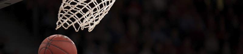 篮球运动员高高跃起扣篮的精彩瞬间，肌肉线条分明